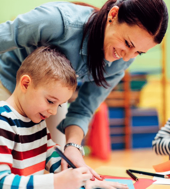 teacher helping student trace hand.