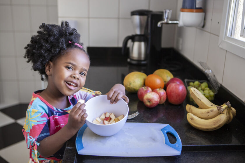 little girl with a bowl of apple slices.