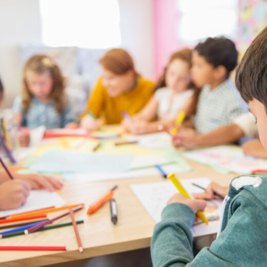 Teacher and students drawing in classroom.