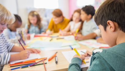Teacher and students drawing in classroom.