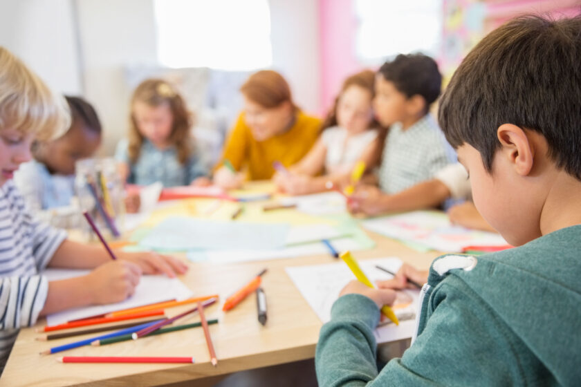 Teacher and students drawing in classroom.